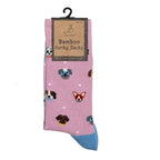 A pair of pink novelty socks with a blue toe and heel, featuring a pattern of various dog faces, hanging from a black plastic hanger with a brown paper label that reads 'Baptistley Bamboo Funky Socks'.