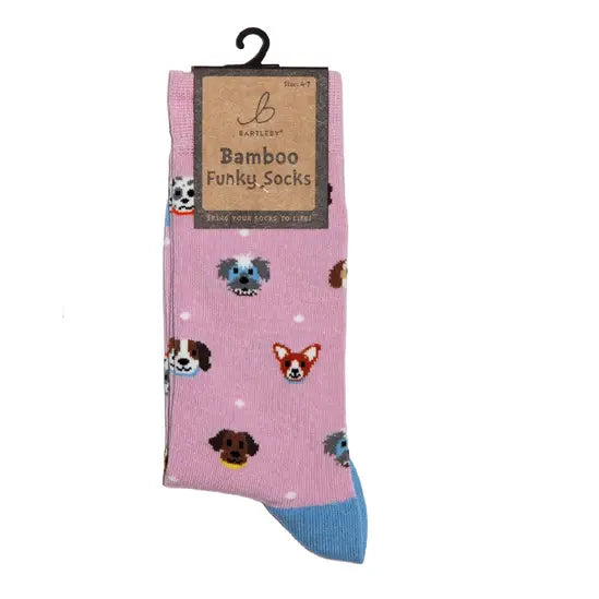 A pair of pink novelty socks with a blue toe and heel, featuring a pattern of various dog faces, hanging from a black plastic hanger with a brown paper label that reads 'Baptistley Bamboo Funky Socks'.