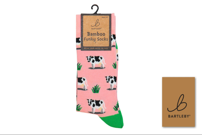 Bartleby Bamboo Funky Socks in pink with a black and white cow print and green heels, shown with its hanger packaging and a small brand card on a white background.